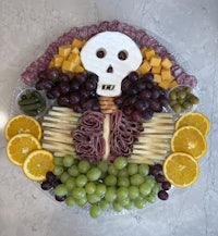 a skeleton shaped platter of fruit and cheese