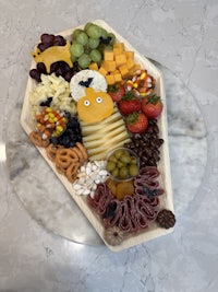 a tray with a variety of cheeses and fruits on it