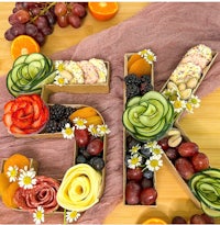 a tray of fruit and vegetables arranged to spell out the word 5k